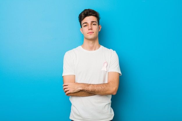 Homme caucasien adolescent avec un arc rose. Concept de lutte contre le cancer.