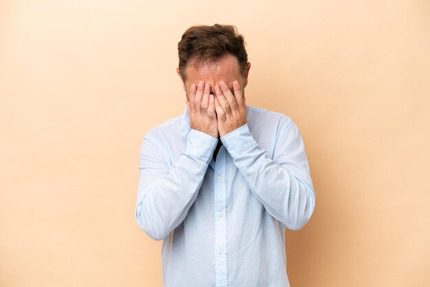 Homme caucasien d'âge moyen isolé sur fond beige avec une expression fatiguée et malade