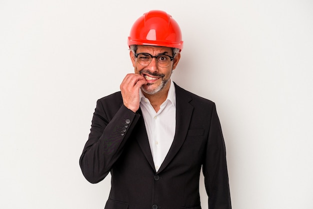 Homme caucasien architecte d'âge moyen isolé sur fond blanc se ronger les ongles, nerveux et très anxieux.