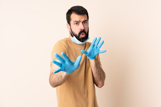 Homme caucasien, à, barbe, protéger, à, a, masque, et, gants, sur, mur, nerveux, étirage, mains, devant