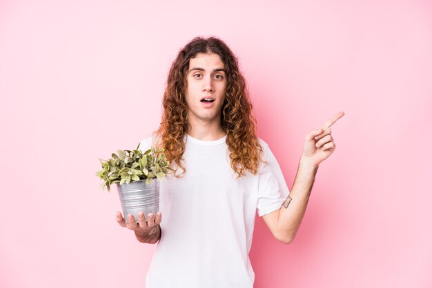 Homme caucasien cheveux longs tenant une plante