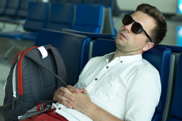 L'homme caucasien dort dans le salon à l'aéroport