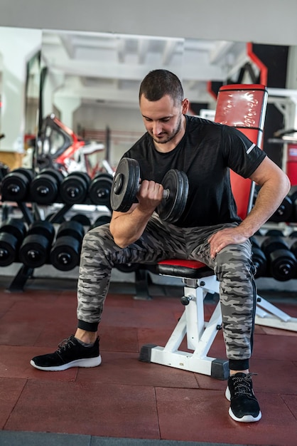 Homme caucasien faisant de l'exercice avec des haltères dans la salle de gym