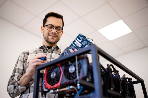 Homme caucasien intelligent travaillant sur un nouveau projet et construisant une plate-forme minière bitcoin