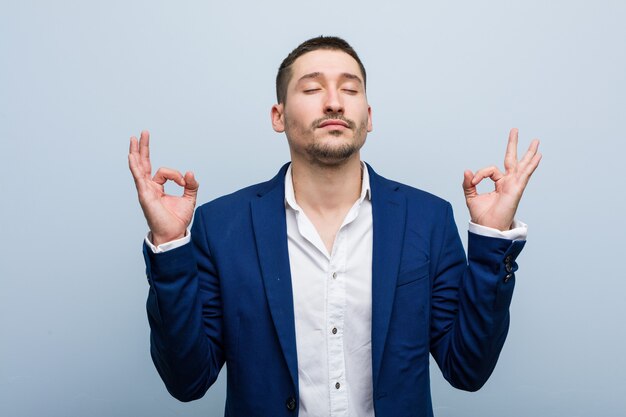 Homme caucasien jeune entreprise se détend après une dure journée de travail, il effectue du yoga.