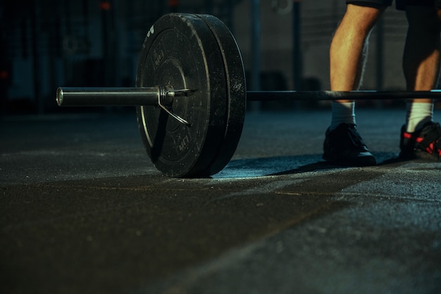 Homme caucasien pratiquant l'haltérophilie dans la salle de sport