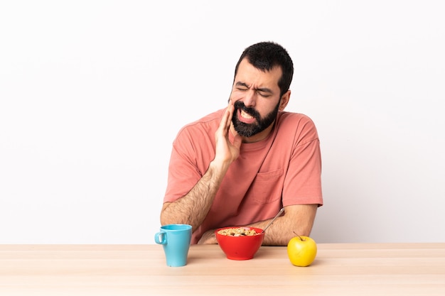 Homme caucasien prenant son petit déjeuner dans une table avec mal de dents