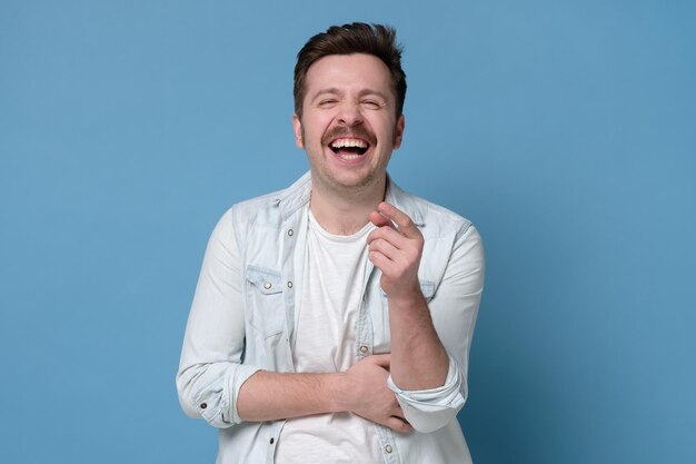 Homme caucasien riant avec moustache Réaction drôle sur blague