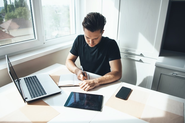 homme caucasien, travailler, ordinateur portable, chez soi, écrire quelque chose