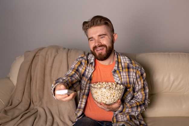 Homme célibataire sur le canapé devant la télé