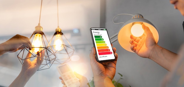 L'homme change une nouvelle main d'ampoule électrique à l'aide de la télécommande de la climatisation ouverte 26 degrés rend une maison plus économe en énergie Appareil ménager économe en énergie