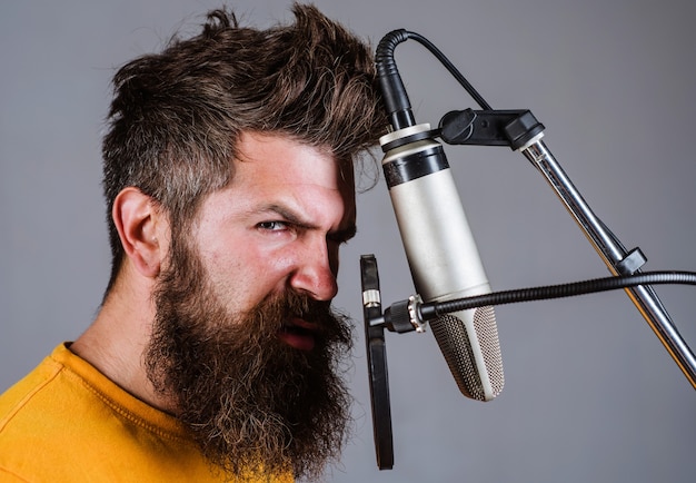Homme chantant avec microphone en studio. Homme barbu en karaoké.