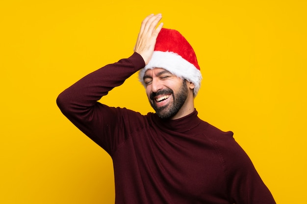 Un homme avec un chapeau de Noël sur un mur jaune isolé a réalisé quelque chose et visait la solution