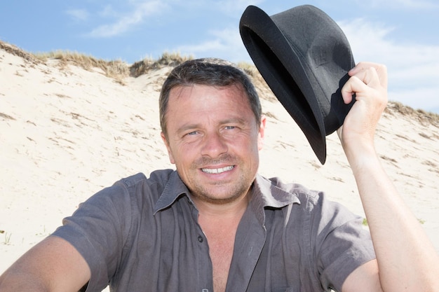 Homme avec un chapeau noir à la plage