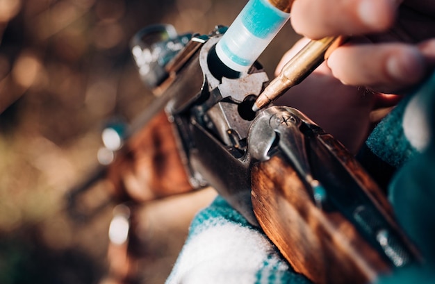Un homme charge un fusil de chasse américain. Un chasseur avec un fusil à chasse à la chasse.
