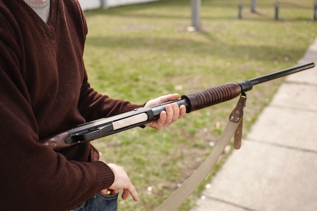 Un homme charge un fusil à pompe en gros plan