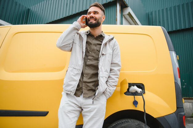 Homme chargeant une voiture électrique au travail