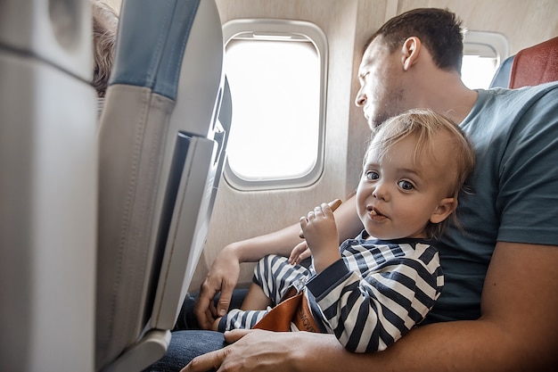 Homme avec charmant bébé en avion