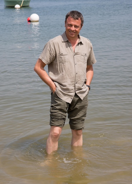 Homme charmant pieds nus à la plage en vacances