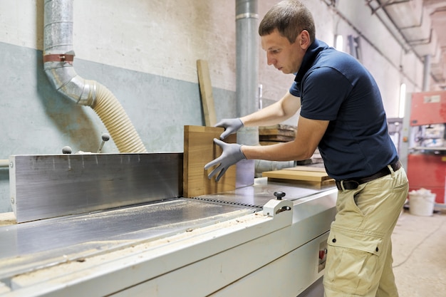 Homme charpentier fabriquant des meubles design en bois pour une commande privée individuelle