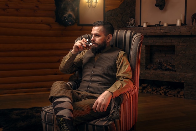 Homme chasseur en vêtements de chasse vintage traditionnels boivent de l'alcool de luxe après une chasse réussie