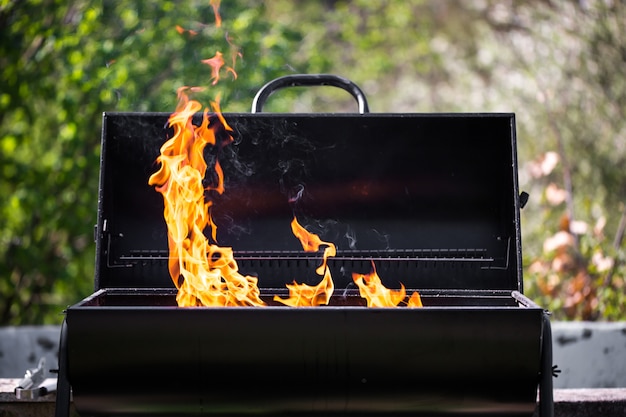 L'homme chauffe le barbecue, se préparant à griller certains types de viande