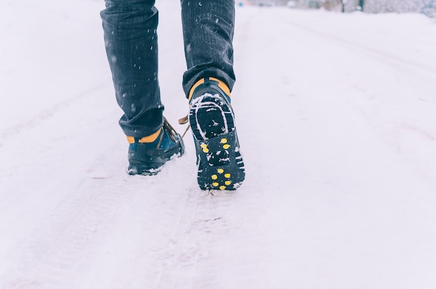 L'homme a des chaussures de glace sur ses chaussures