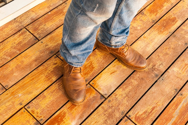 Photo homme avec des chaussures marron sur bois