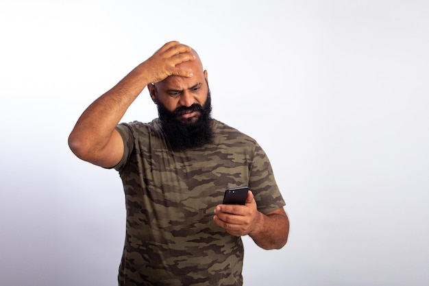 Homme chauve d'âge moyen en bonne santé indien Notification ou message surpris regardant un téléphone portable