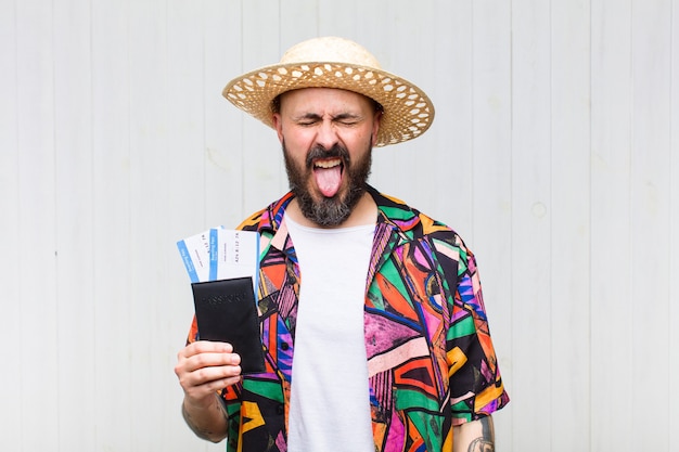 Homme chauve avec une attitude joyeuse, insouciante et rebelle, plaisantant et tirant la langue, s'amusant