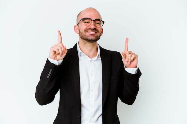 Homme chauve caucasien jeune entreprise isolé sur mur bleu indique avec les deux doigts avant montrant un espace vide.