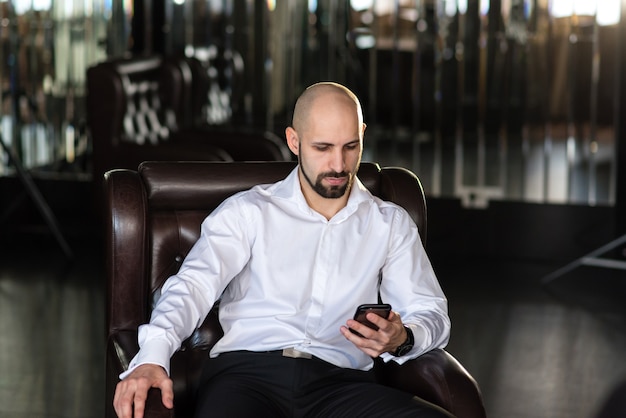 Un homme chauve parle au téléphone