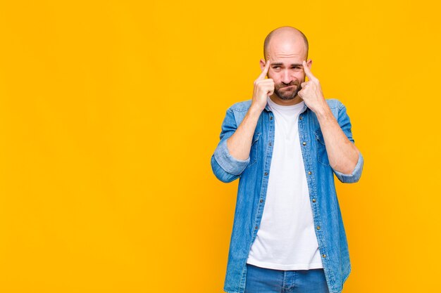 Homme chauve à la recherche de concentration et de réflexion sur une idée, imaginant une solution à un défi ou un problème