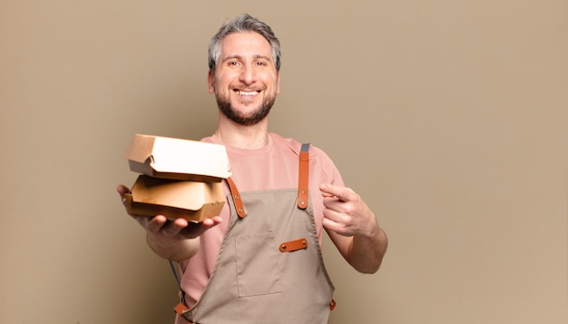 Homme de chef d'âge moyen avec des hamburgers