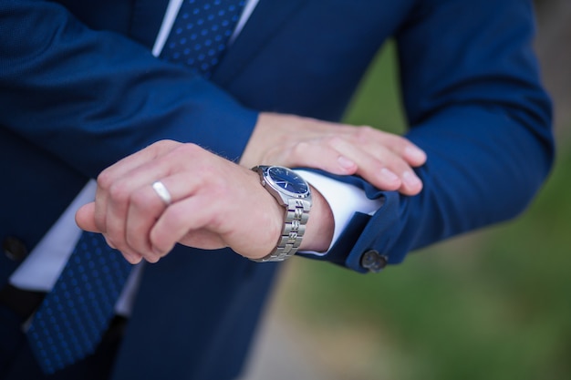 L'homme en chemise blanche et cravate bleue porte des montres.