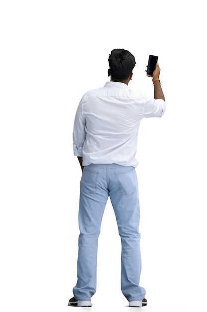 Photo un homme en chemise blanche sur fond blanc en pleine hauteur agitant son téléphone à l'arrière