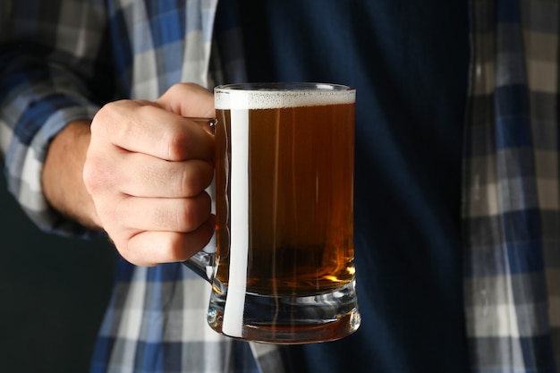 Homme en chemise à carreaux tenir un verre de bière