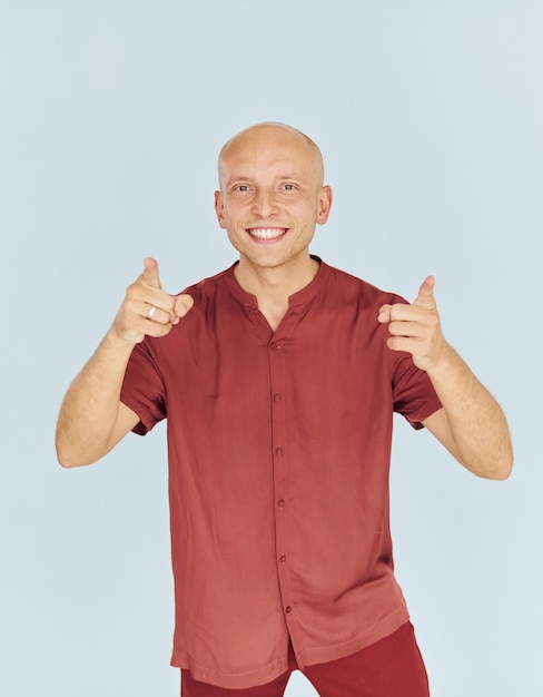 L'homme en chemise décontractée rouge est debout sur fond blanc