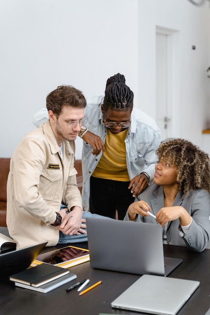 un homme avec une chemise jaune est assis à un bureau avec un ordinateur portable et une femme dans une chemise Jaune