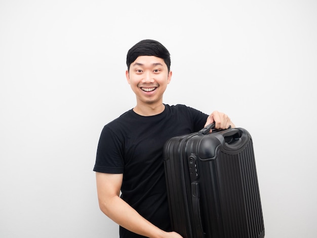 Homme chemise noire porter des bagages souriant portrait blanc isolé
