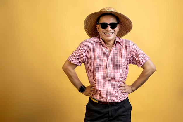 Homme avec une chemise portant des lunettes de soleil et un chapeau debout
