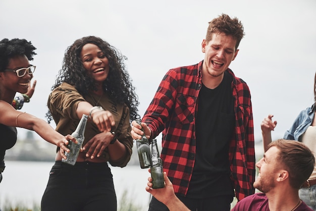 L'homme en chemise rouge est totalement ivre. Les gens font la fête dehors. Des amis multiethniques se réunissent le week-end.