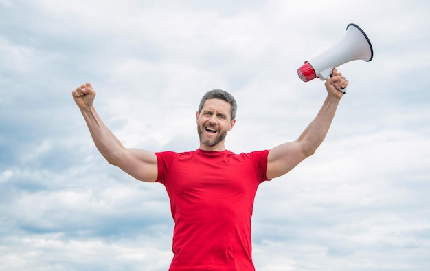 Homme en chemise rouge avec haut-parleur sur fond de ciel