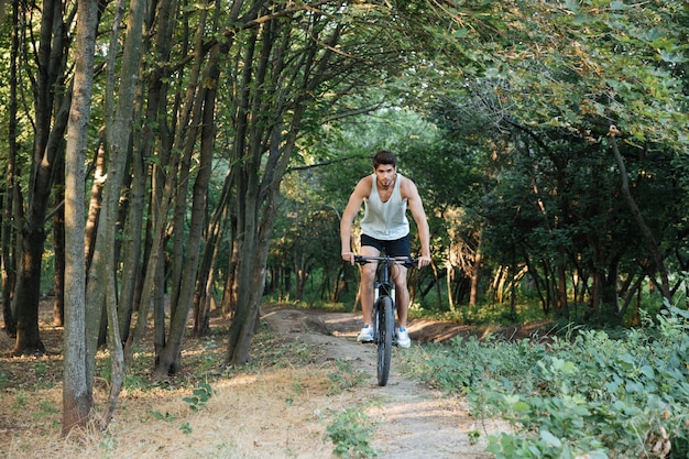 Homme chevauchant à travers les bois