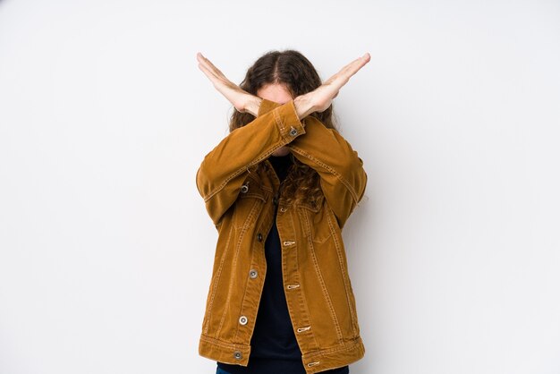 Homme cheveux longs posant isolé gardant deux bras croisés, concept de déni.