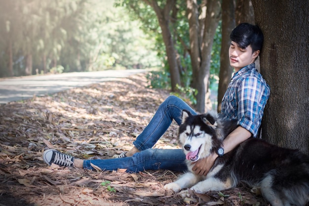 Un homme avec un chien assis dans la forêt