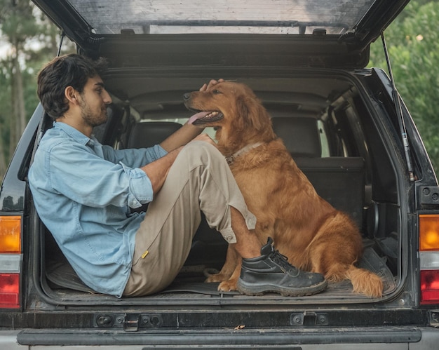 Un homme avec un chien assis dans une voiture
