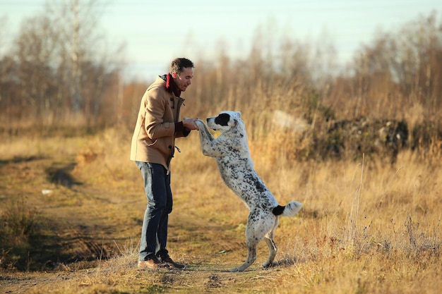 Un homme avec un chien debout sur le terrain