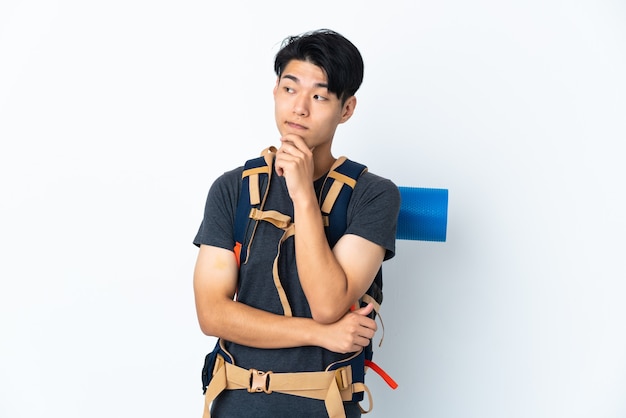 Homme chinois alpiniste avec isolé sur fond blanc ayant des doutes et de la pensée