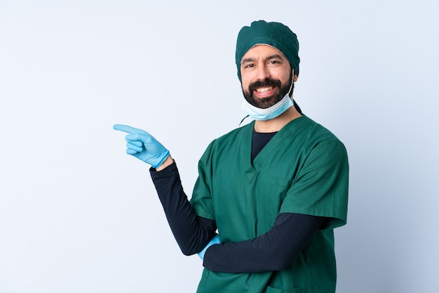 Homme chirurgien en uniforme vert sur mur pointant le doigt sur le côté